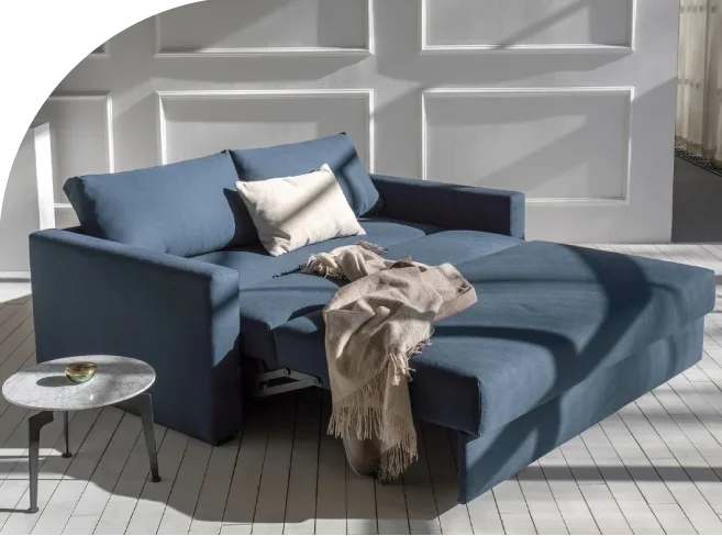 fully extended blue sofa bed infront of panel wall
